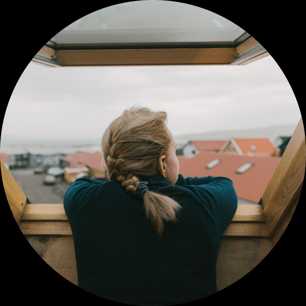 person leaning out of a window getting fresh air